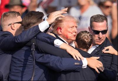 Donald Trump foi retirado do palco com a orelha sangrando (Foto/Reprodução X @adinross)