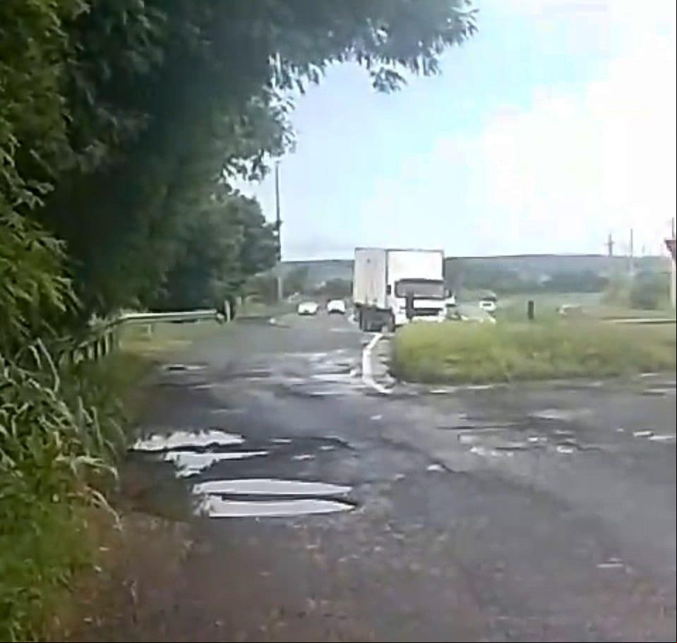 Os buracos e galhos estão na entrada do bairro, em paralelo com a BR-262. (Foto/Reprodução vídeo)